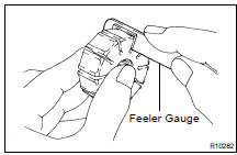 (b) Using a feeler gauge, measure the clearance between