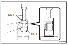 Using SST and a press, remove the bushing.