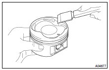 (a) Using a gasket scraper, remove the carbon from the piston